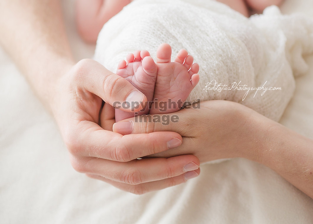 baby feet held by hands